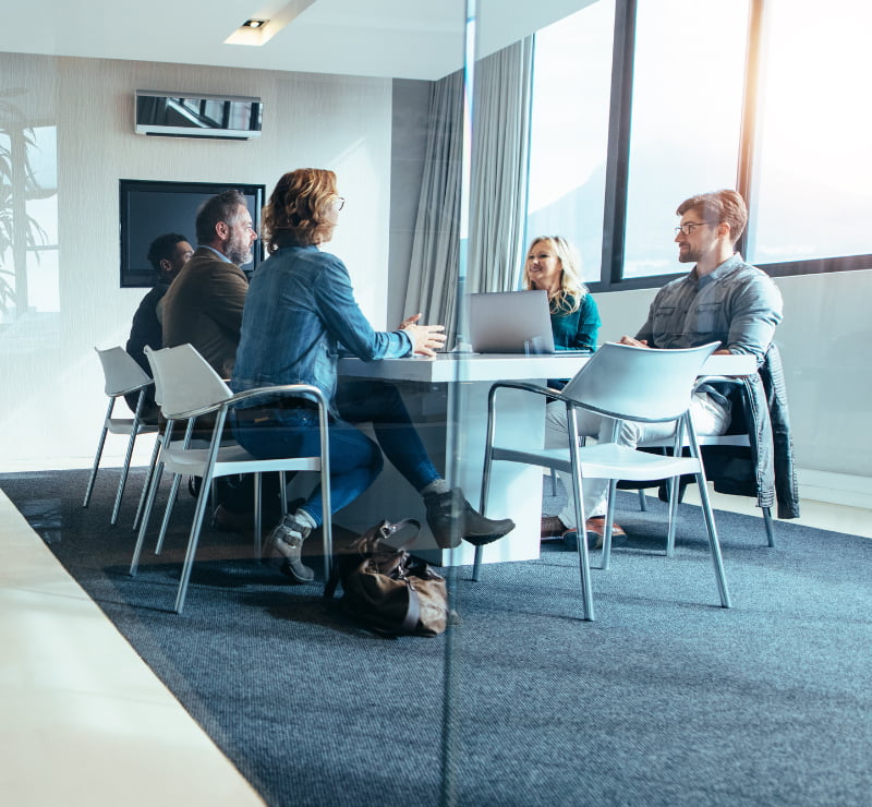 Kuoni Tumlare colleagues in conversation around a meeting table