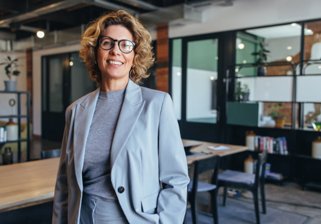 A confident colleague smiling in an open office setting