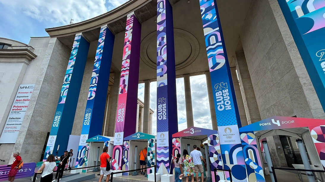 경기장 호스피탈리티 라운지 바로 밖, Clubhouse 24의 넓고 우아하게 조명된 입구. 플러시 좌석, 모던 인테리어, 환영 사인이 있다.