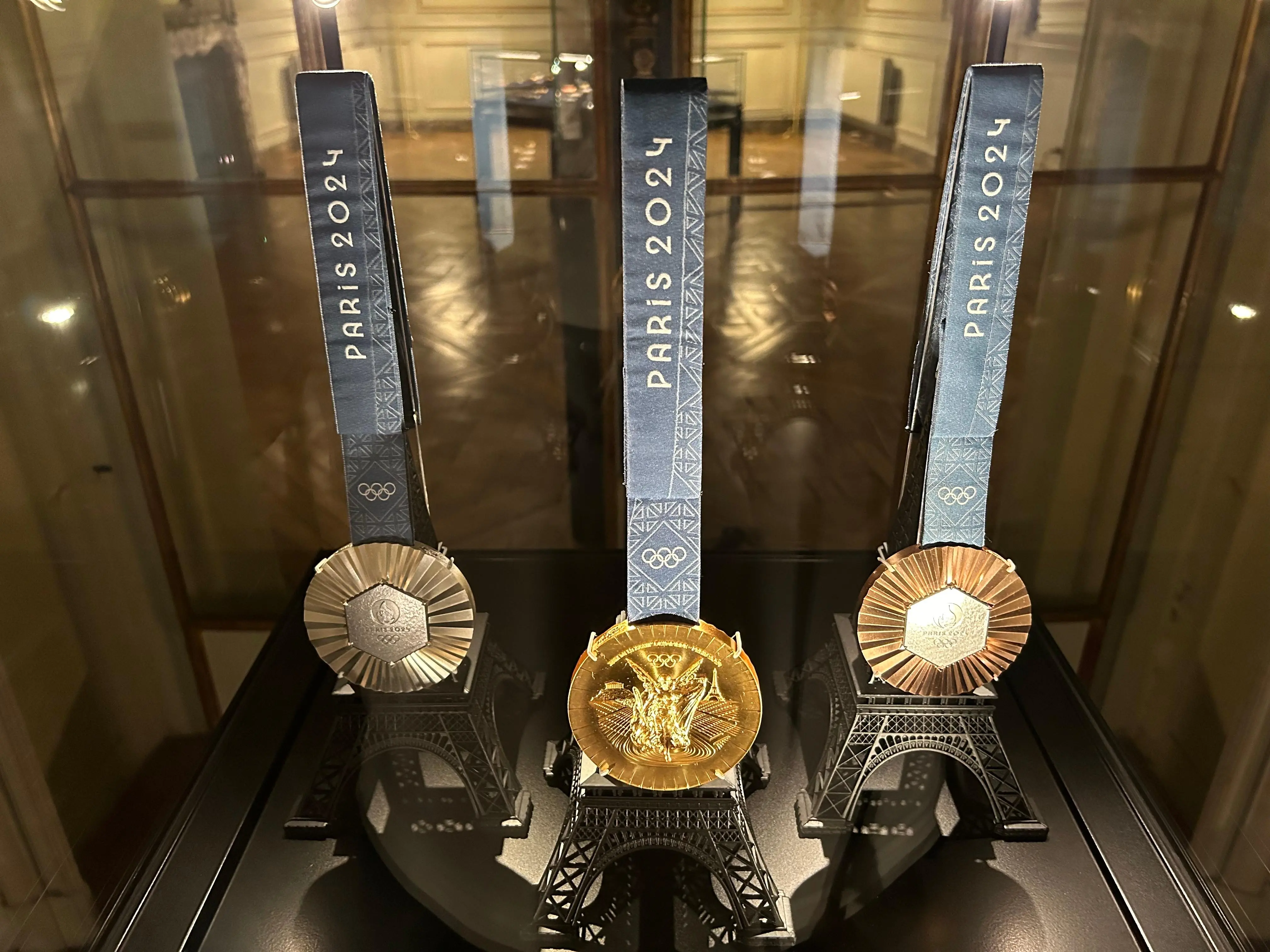 파리 2024 올림픽 성화봉 3개가 유리 케이스 안에 전시되어 있다.