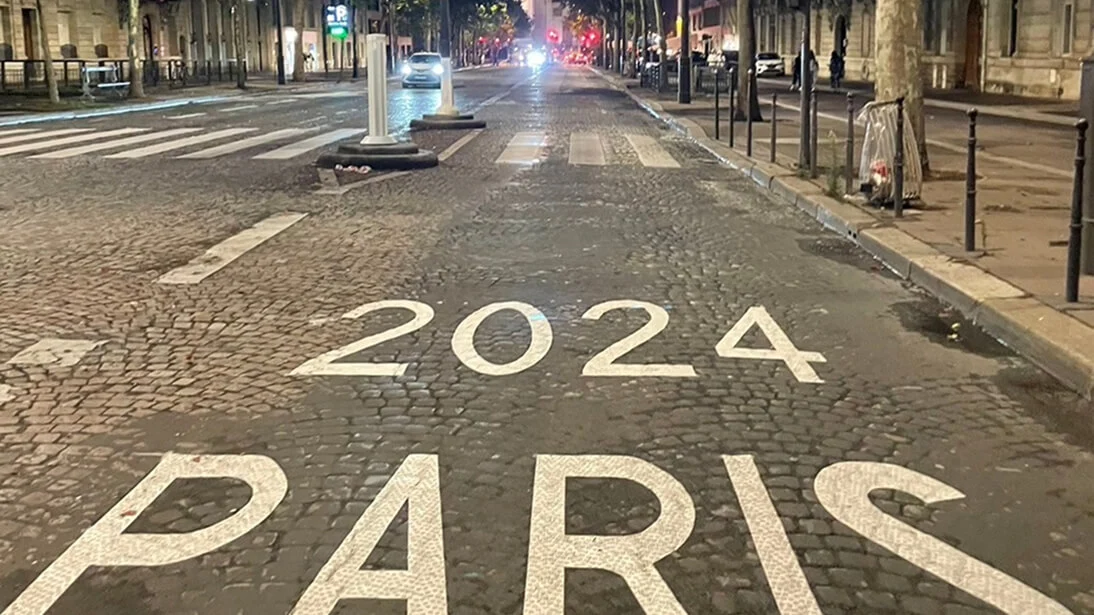 야간, 나무가 늘어선 파리 거리 끝에 개선문이 보이고, 자갈길 바닥에 