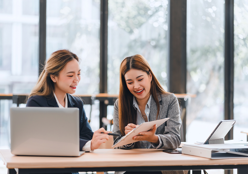 KT - 2 businesswomen looking at document