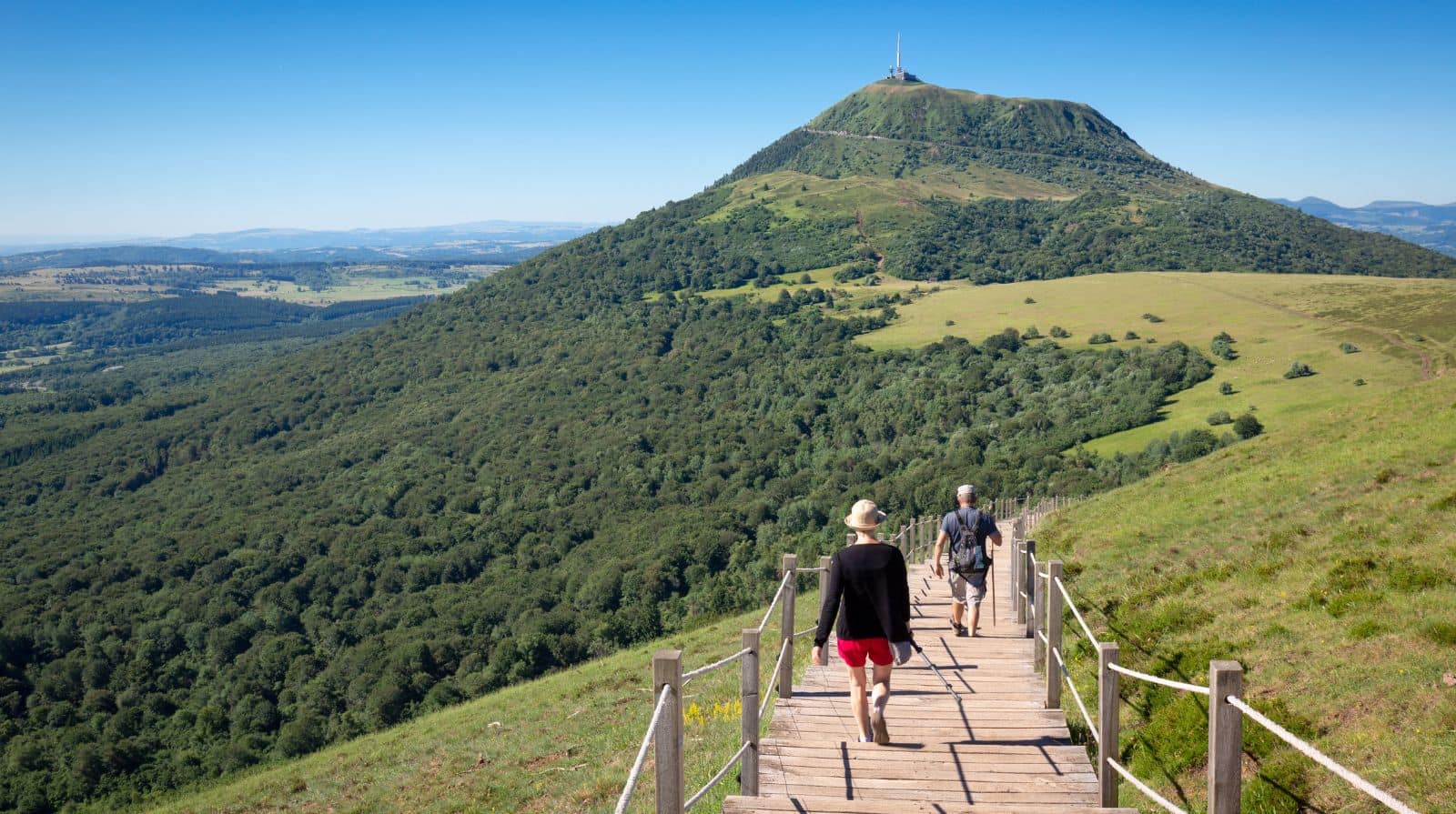  Hikers on trail in the Puy-de-Dôme, Auvergne, on a sustainable group travel itinerary through central France
