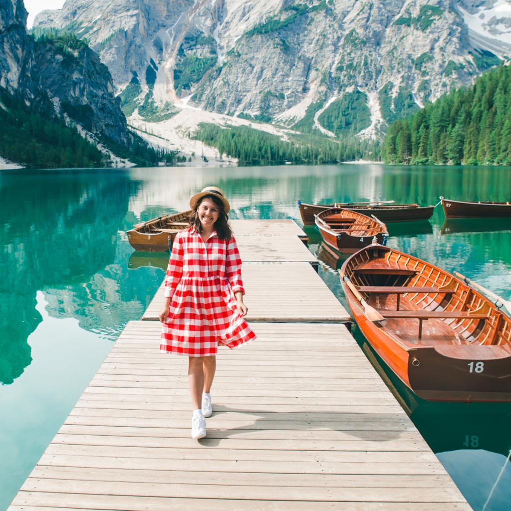 Ladyin checkered dress walking along pier in Swiss alps