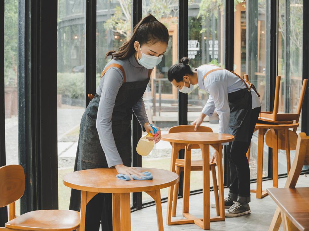 Restaurant staff cleaning tables and wearing face masks