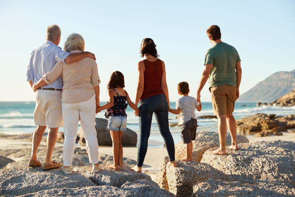 Family on a sunny beach looking out to the ocean