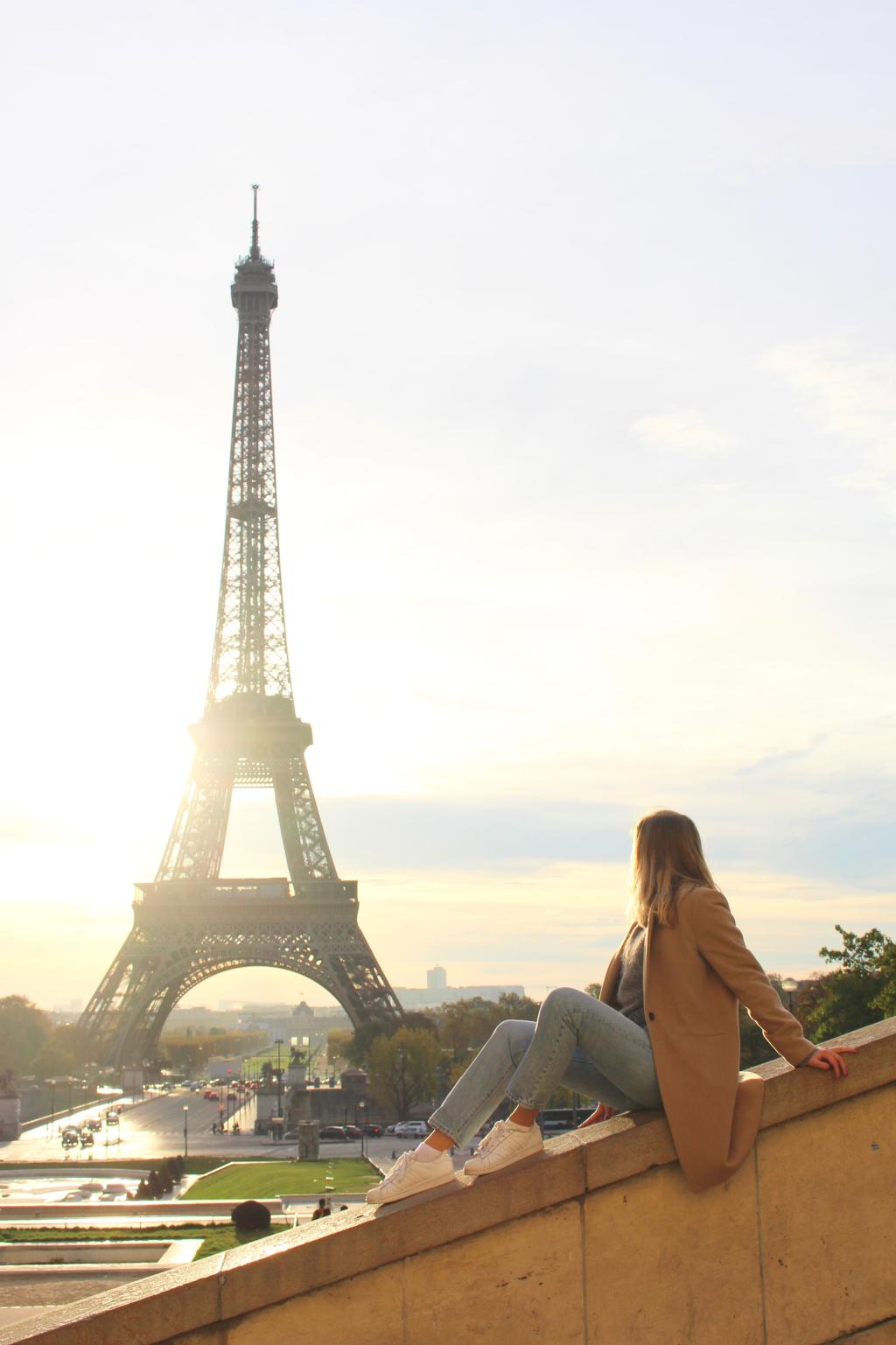 Woman looking at the Eiffel tower in Paris during sunset